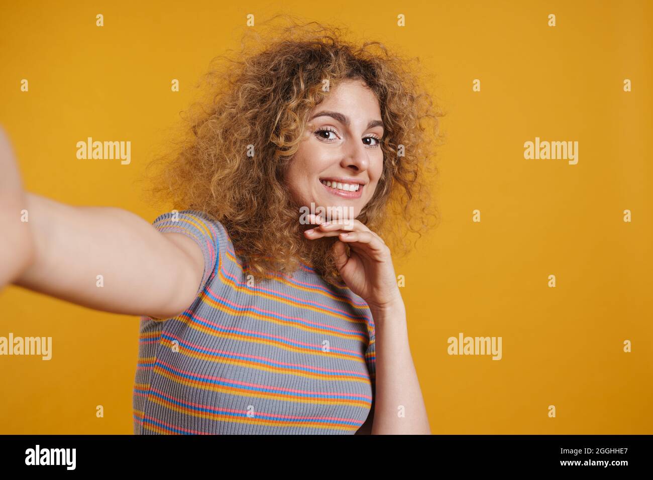 Happy smiling young blonde woman with fizzy hair in casual clothes ...