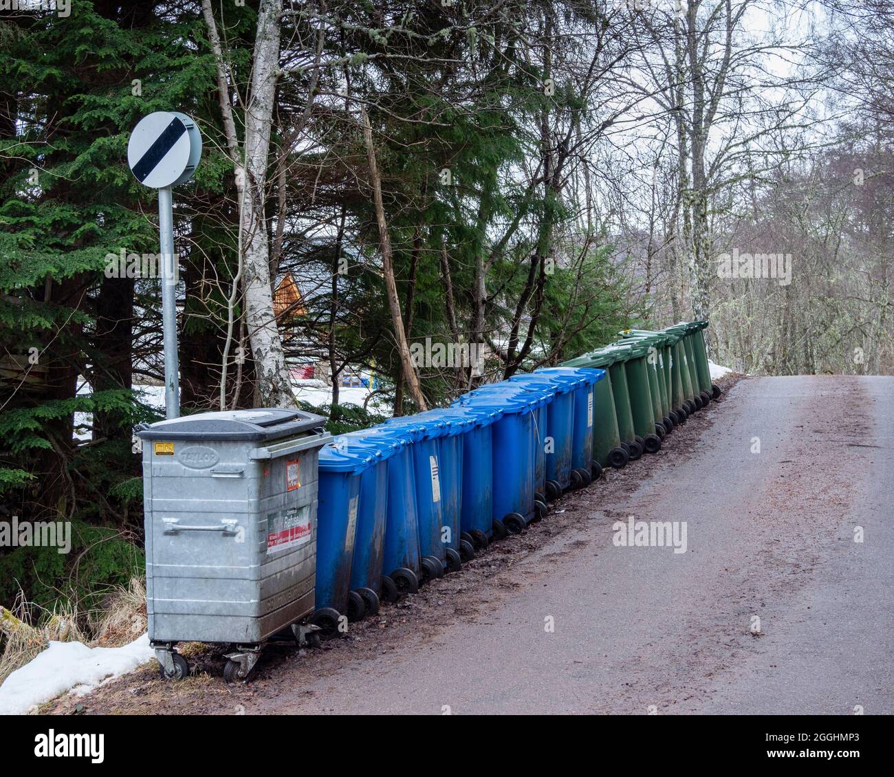 A row of commercial waste, blue recycling and green refuse bins at the end of a narrow lane, Highland, Scotland Stock Photo