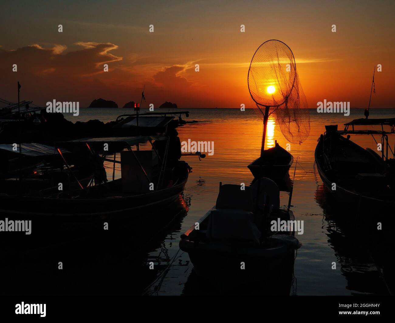 Wooden boat moored in shallow water near the beach at sunset. Romantic ...