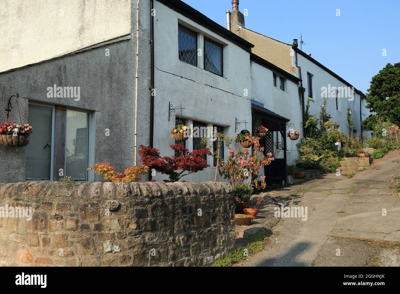White painted terraced houses off Main Street, Heysham, Lancaster, Lancashire, England, United Kingdom Stock Photo