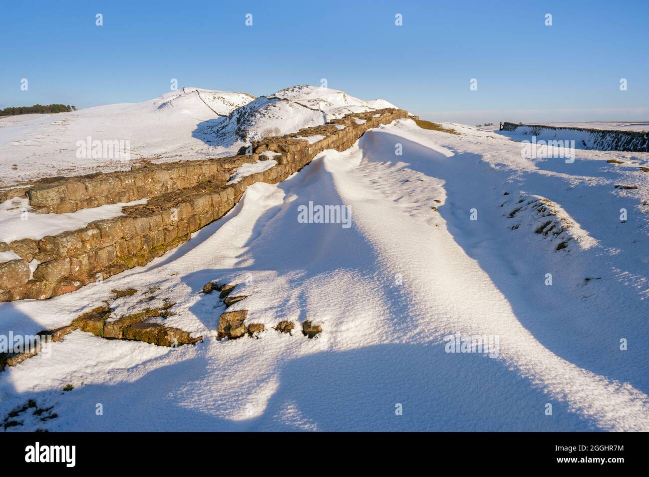 Northern England, Northumberland National Park landscape, Hadrian's Wall in winter snow on a bright sunny day with clear blue sky Stock Photo