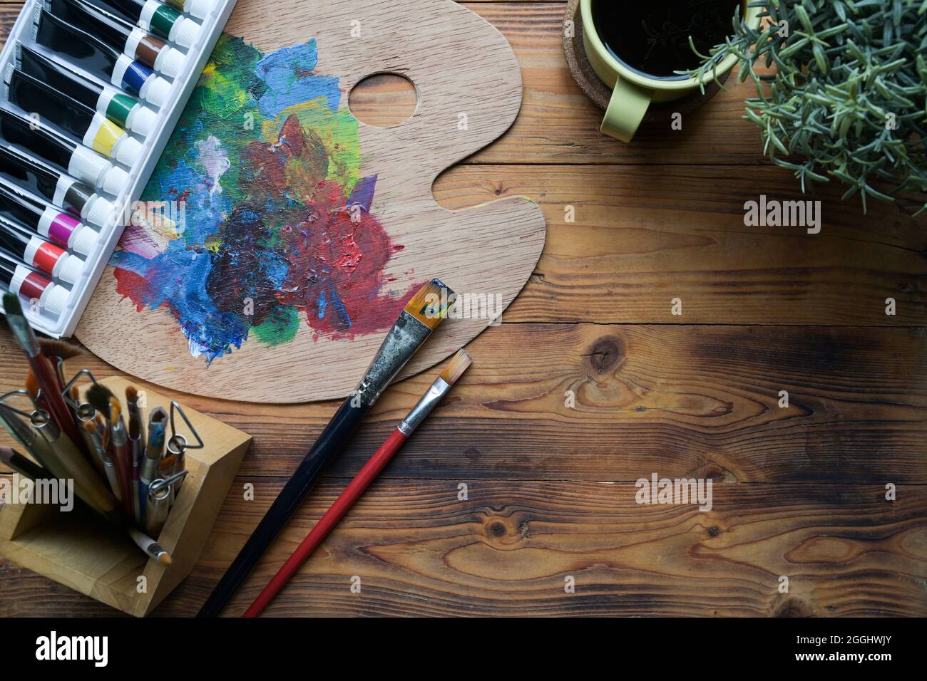 Artist's workshop. Canvas, paint, brushes, palette knife lying on the  table.Art tools.Artist workplace background.Acrylic paint and brushes.Art  picture with copy space and for add text. Stock Photo