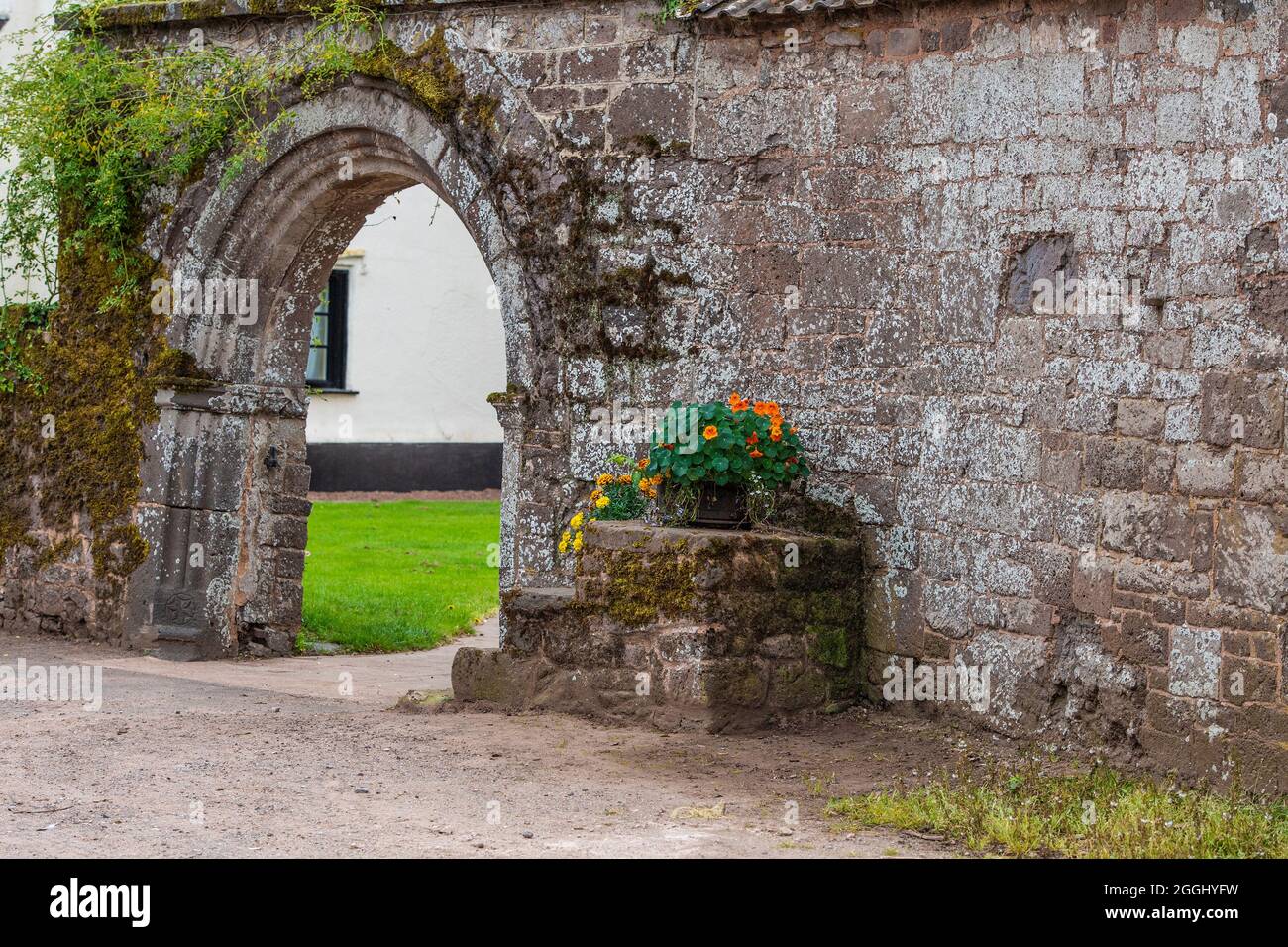 archway into walled garden and mounting block Stock Photo