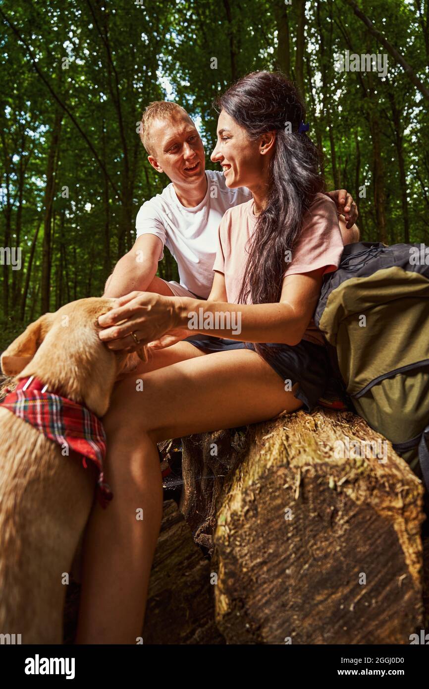 Happy young couple with dog enjoying fresh forest air Stock Photo - Alamy