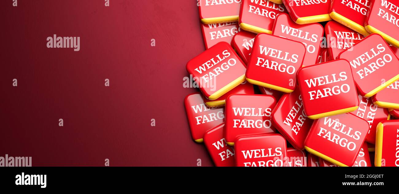 Logos of the financial services company Wells Fargo on a heap on a table. Copy space. Web banner format. Stock Photo