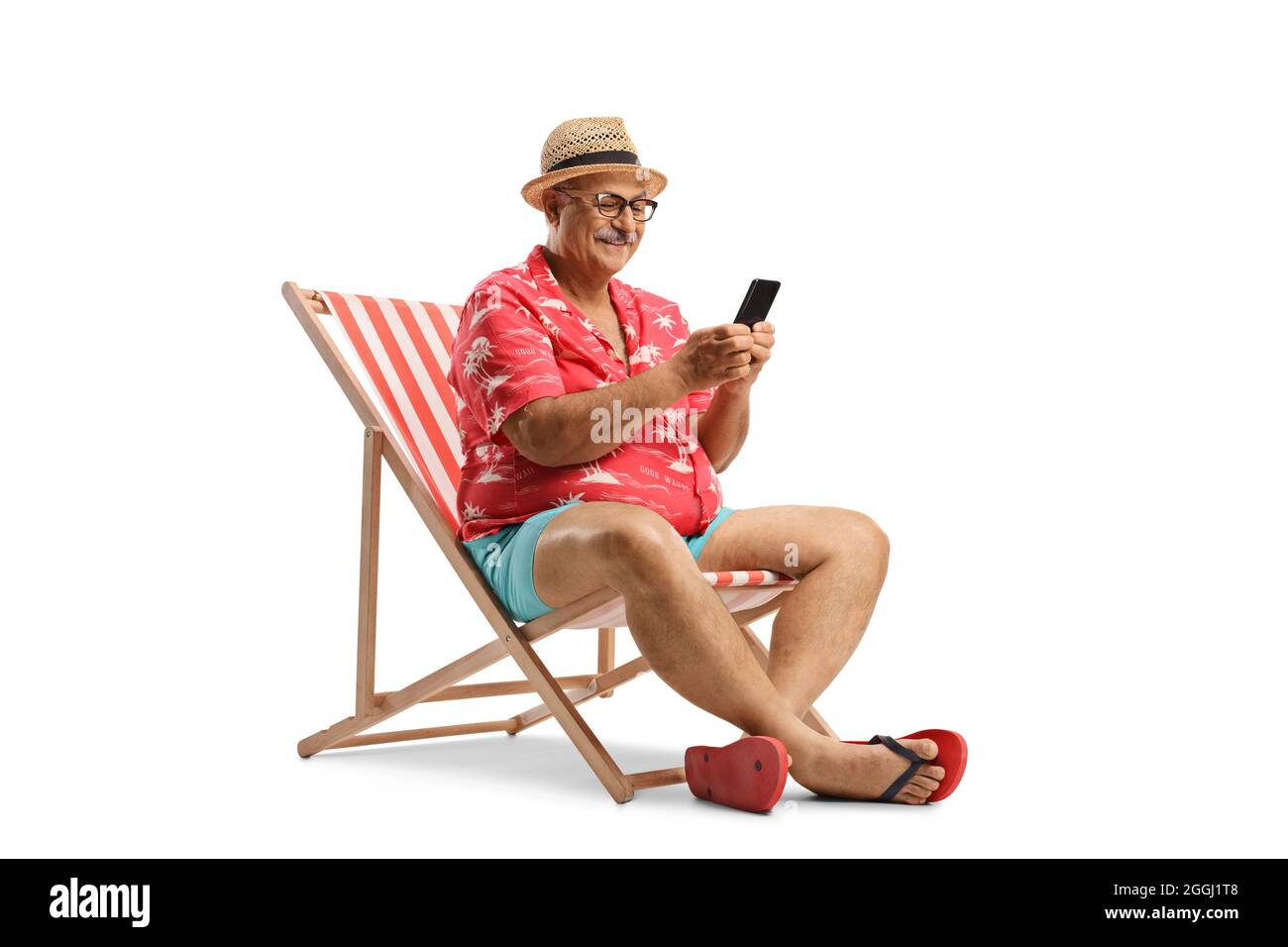 Elderly man relaxing in a beach chair and using a smartphone