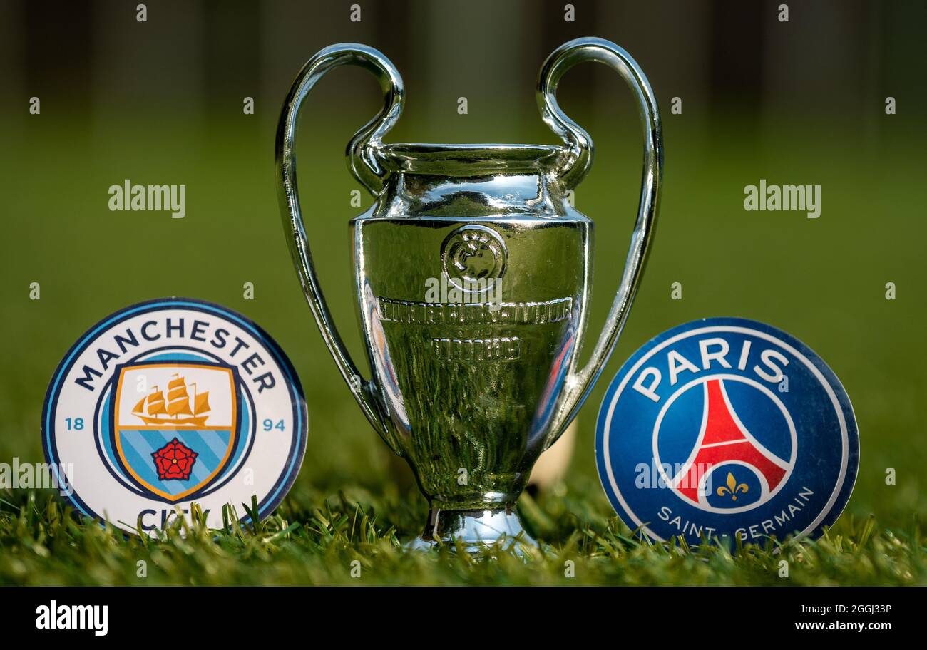 August 27, 2021 Manchester, UK. The emblems of the football clubs Paris Saint-Germain F.C. and Manchester City F.C. and the UEFA Champions League Cup Stock Photo