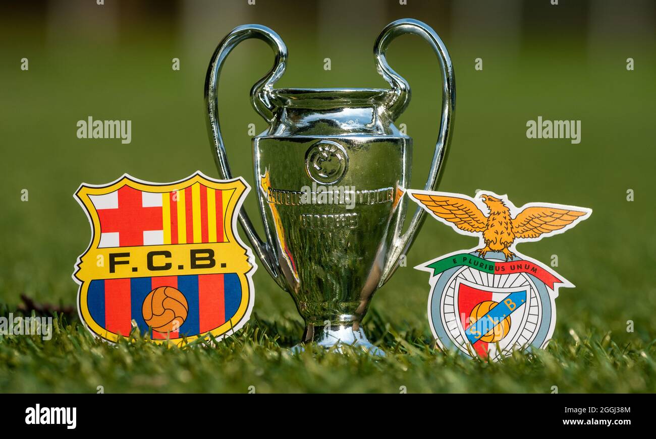 August 27, 2021 Barcelona, Spain. The emblems of football clubs S.L. Benfica and FC Barcelona and the UEFA Champions League Cup on the green lawn of t Stock Photo
