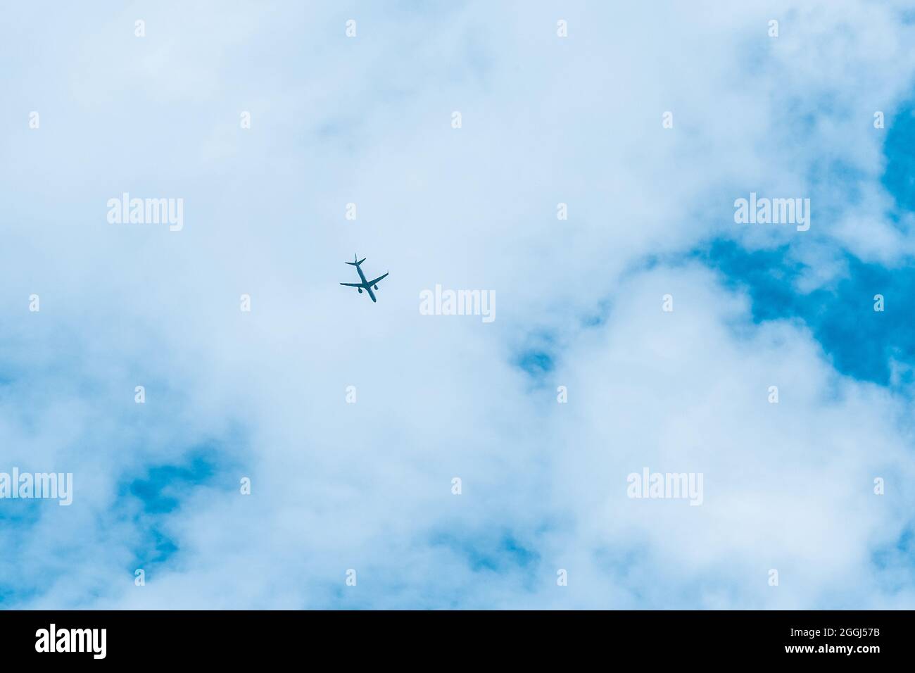 The plane flies in a big blue sky with white clouds background Stock ...