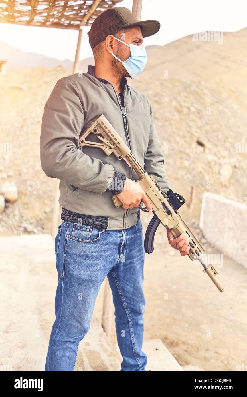 Men practicing shooting with a assault rifle at target. Selective Focus Stock Photo