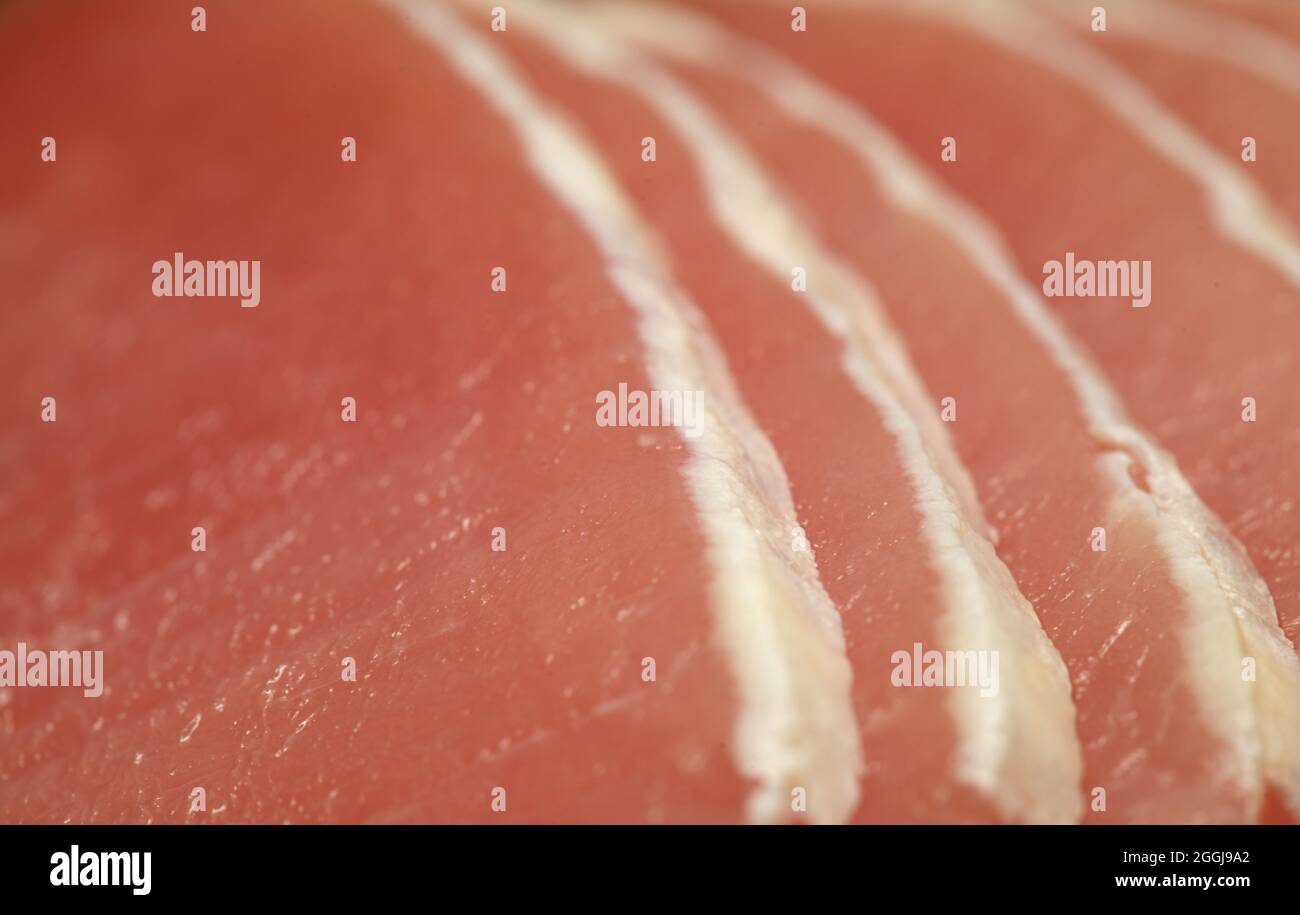Raw marinated pork lean loin cut into thin sliced with almost all of the fat trimmed Stock Photo
