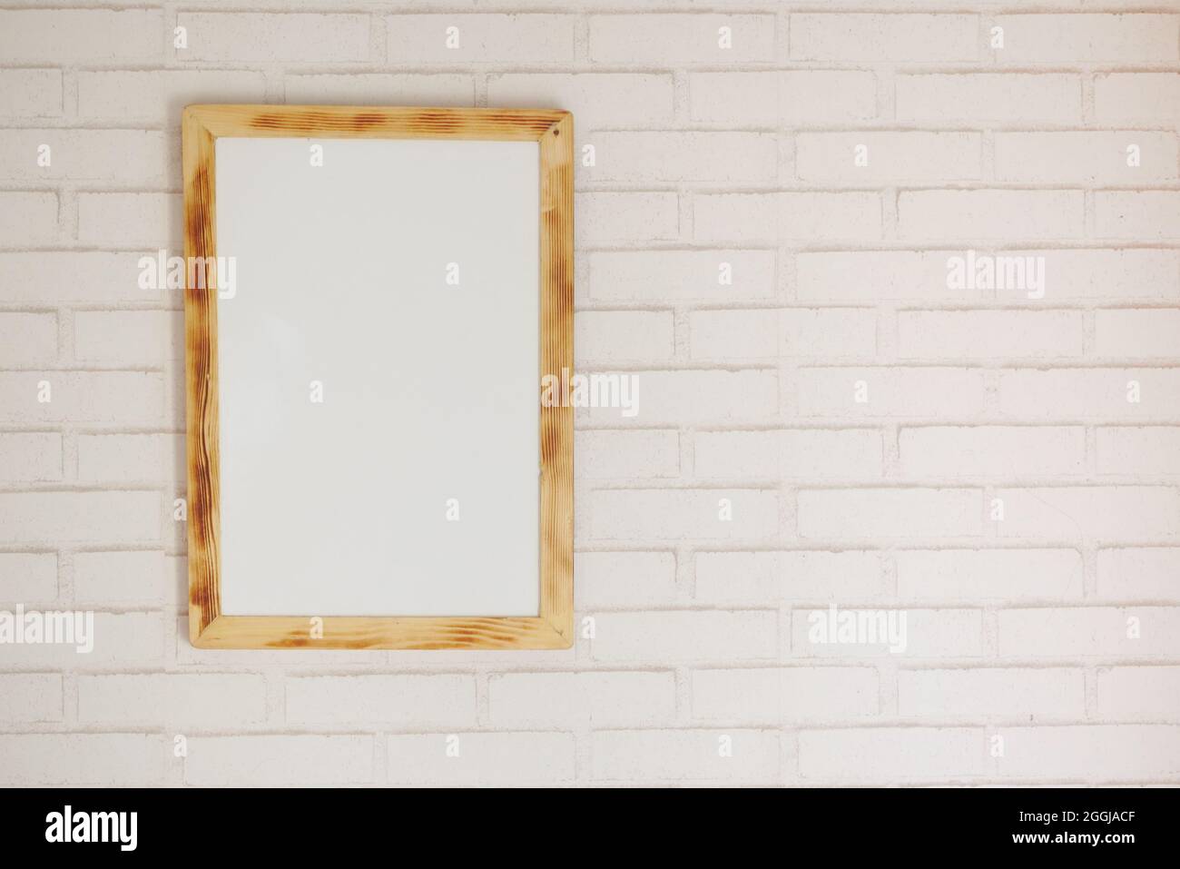 Black frame mockup on table against white wall, Stock Photo