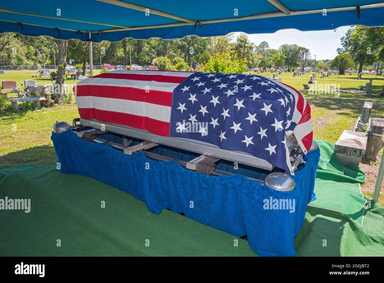 Graveside service for a former military veteran with an American Flag draped coffin.symbol Stock Photo