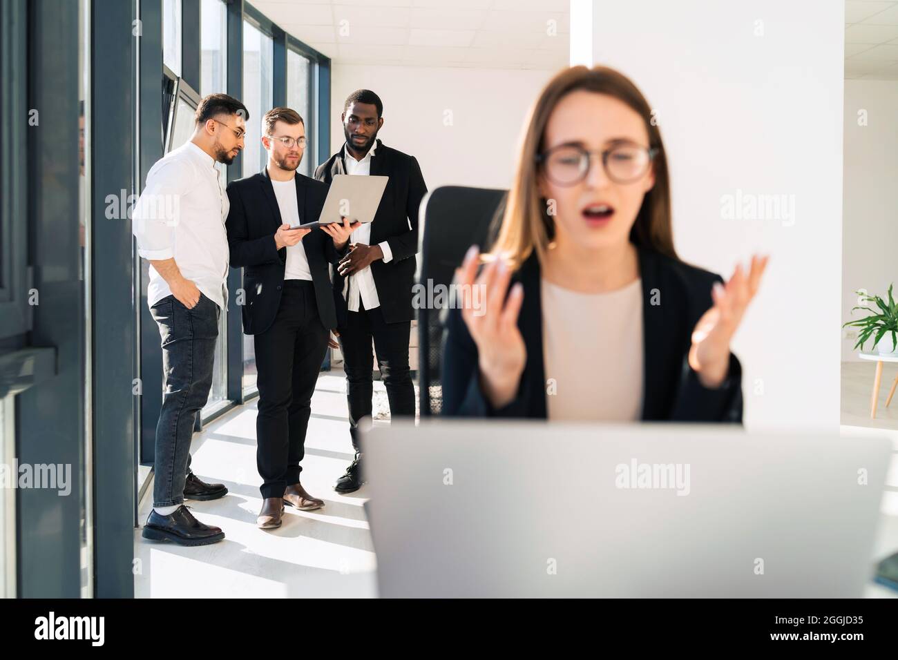 Frustrated female office worker looking at laptop Stock Photo