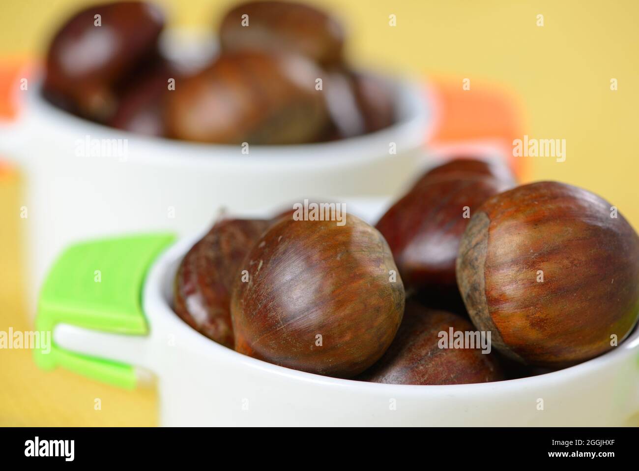 portuguese nuts in ceramic container on table with yellow jute Stock