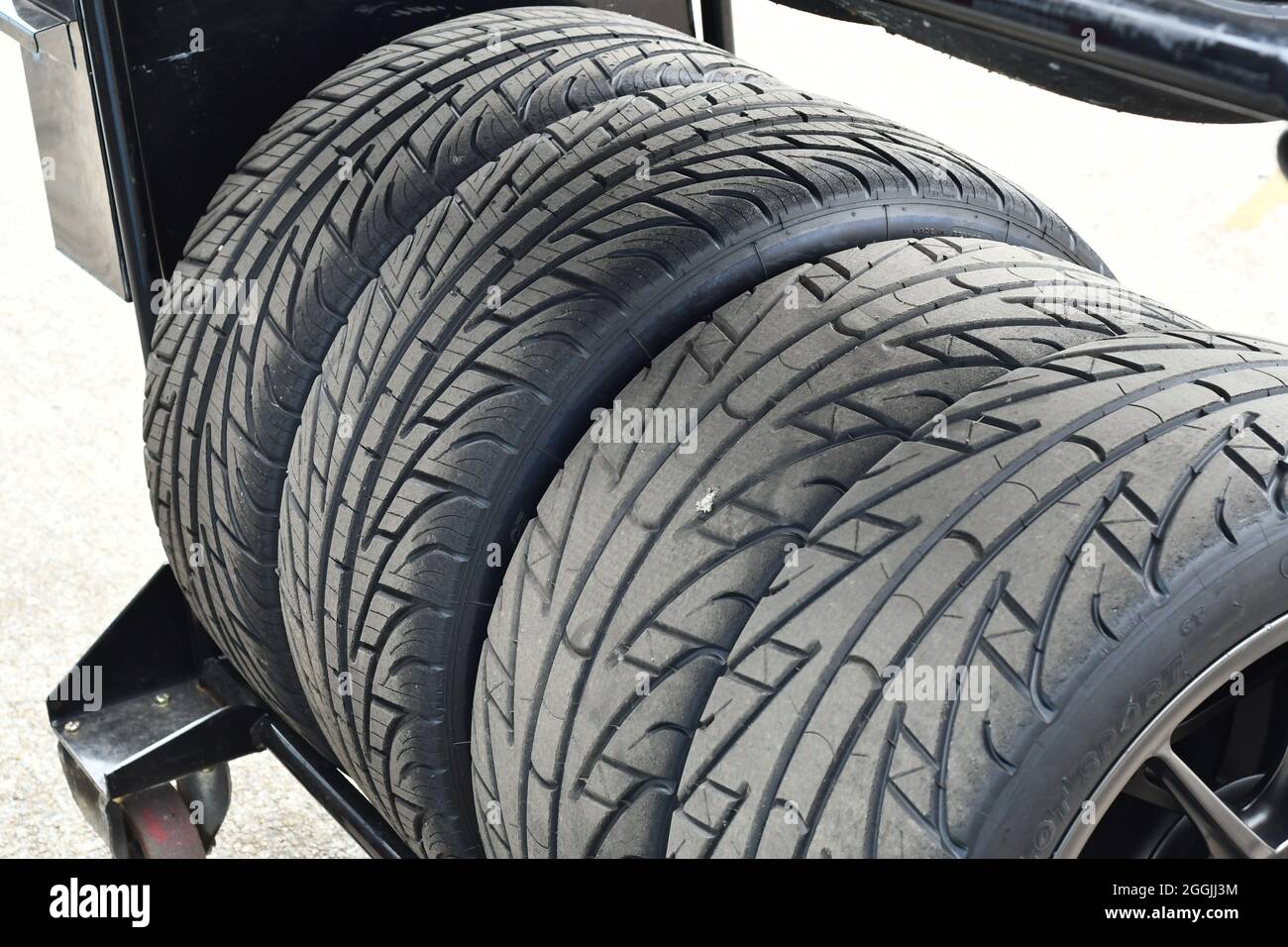 A set of four wet weather racing car tyres on their wheeled stand Stock Photo