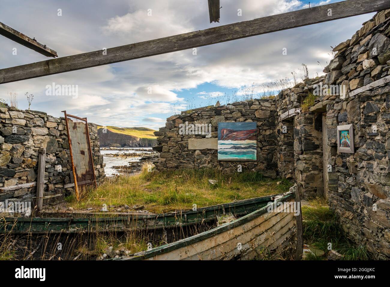 An old ruined and roofless building with old boats makes for an unusual art gallery at Skerray Bay on the north coast of Scotland just off the NC500. Stock Photo