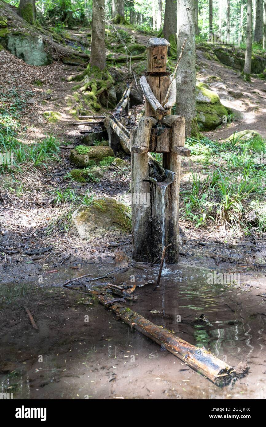 Europe, Germany, Baden-Wuerttemberg, Swabian Forest, Murrhardt, artistically carved wooden figure on a stream in the Murrhardt Forest Stock Photo