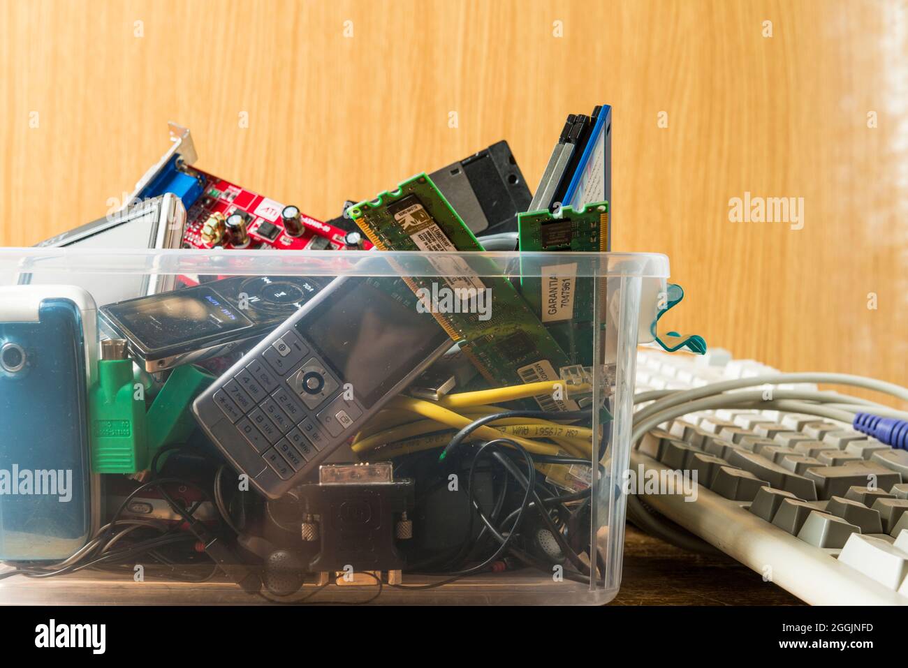 Obsolete electronic and technological objects in a plastic box. Technological waste and its recycling is one of the issues to be addressed for the car Stock Photo