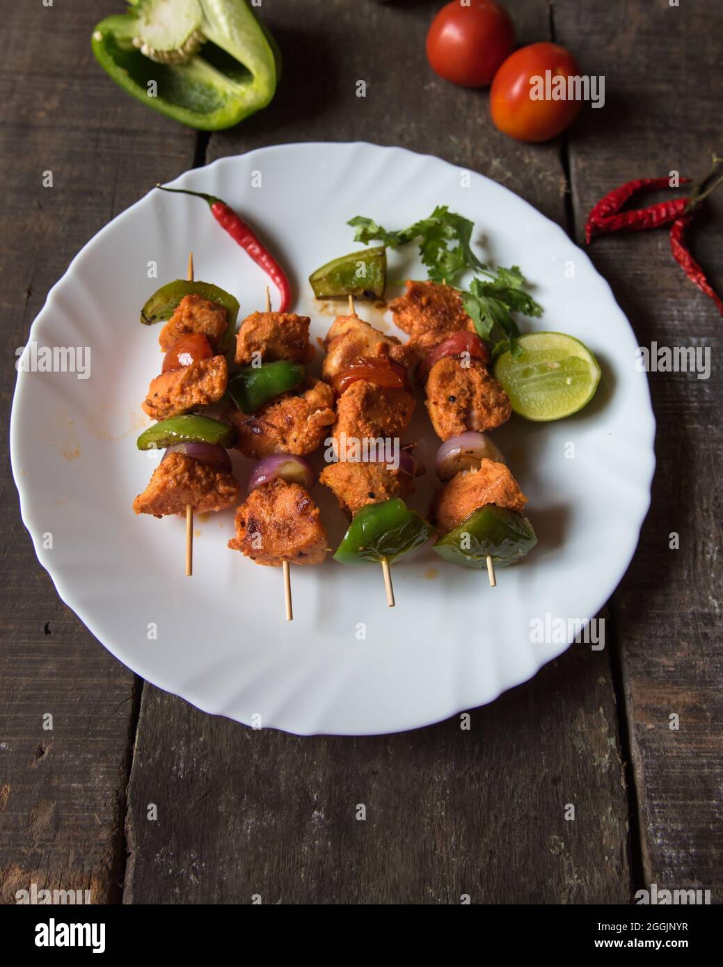 Chicken kebabs or doners grilled with saute vegetables in a white plate. Close up. Stock Photo