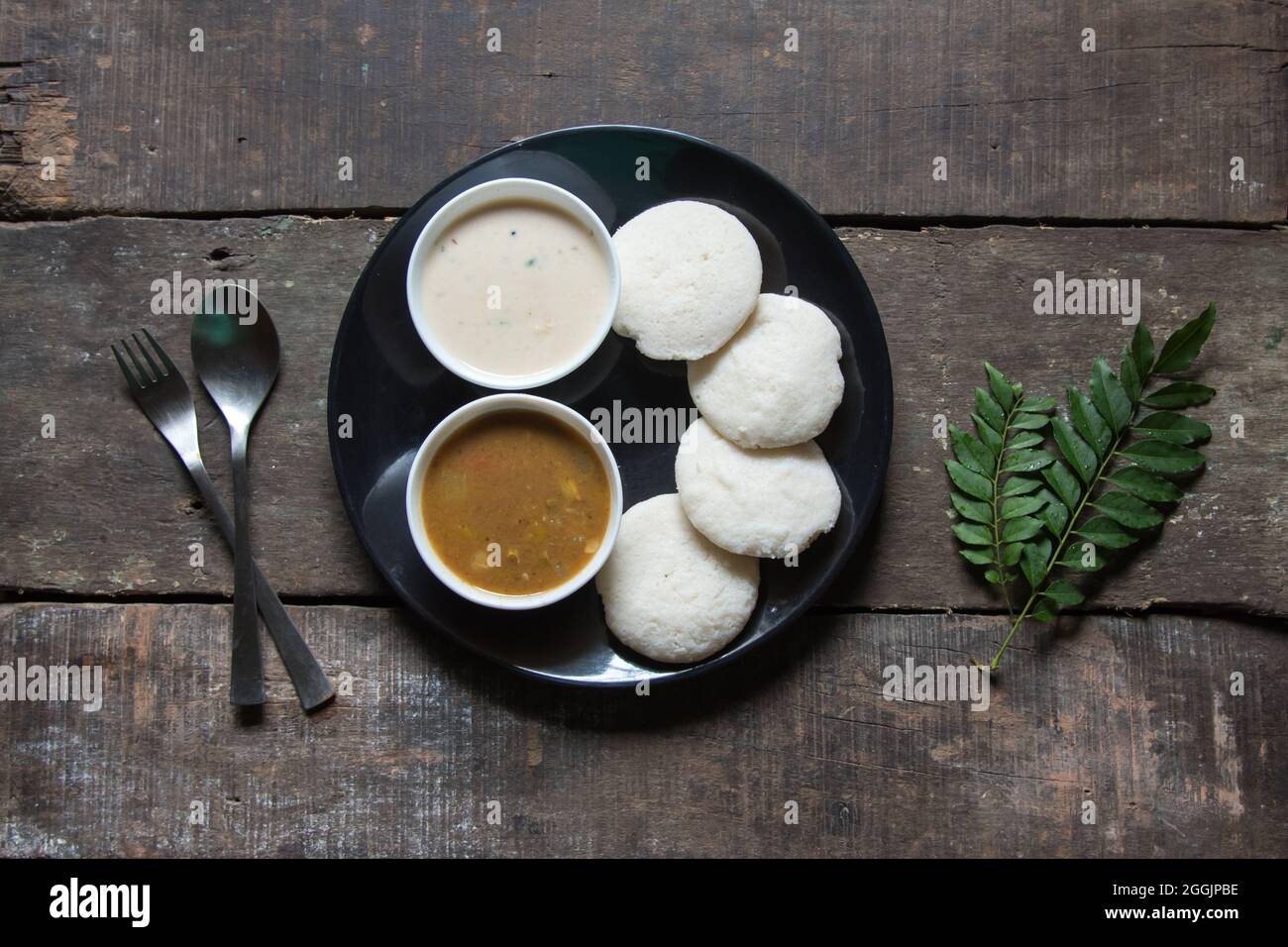 South Indian snacks idli sambar or idly sambhar prepared by steaming fermented rice and served with coconut dip and vegetable soup. Stock Photo