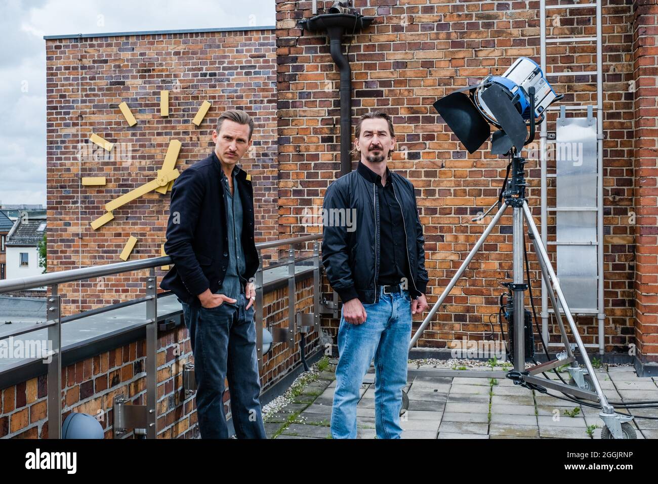 Leipzig, Germany. 30th Aug, 2021. Actors Johannes Hendrik Langer (l) as Moritz Brenner and Till Wonka as Bent Brenner stand on the sidelines of filming for the crime series 'Soko Leipzig' and the episode 'Schlüssel zur Wahrheit' (AT) on the roof of the Konsumzentrale. A broadcast date has not yet been set. Credit: Kirsten Nijhof/dpa-Zentralbild/dpa/Alamy Live News Stock Photo