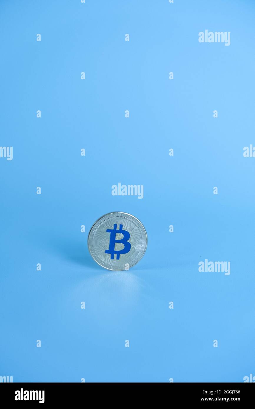 One Bitcoin silver coin color with the letter 'B' on Blue color, centered in a light blue background. Bitcoin - BTC Bit Coin - Crypto currency. Stock Photo