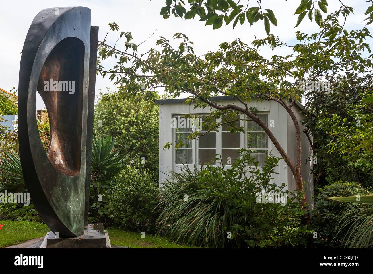 Two Forms (Divided Circle) 1969, and the summerhouse: Barbara Hepworth Sculpture Garden, St Ives, Cornwall Stock Photo