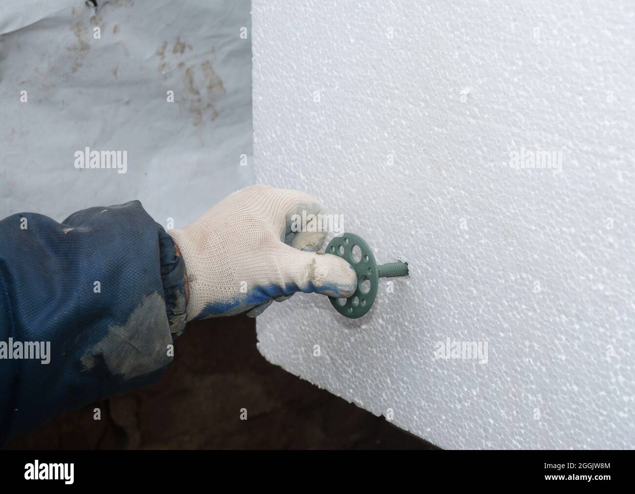 Contractor installing styrofoam rigid insulation board. How to attach