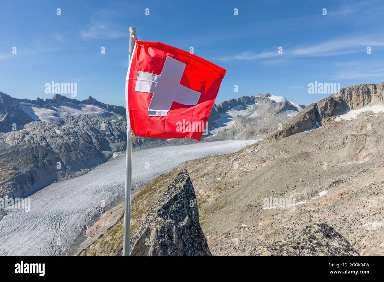 Swiss flag in front of alpine panorama in the high mountains Stock Photo