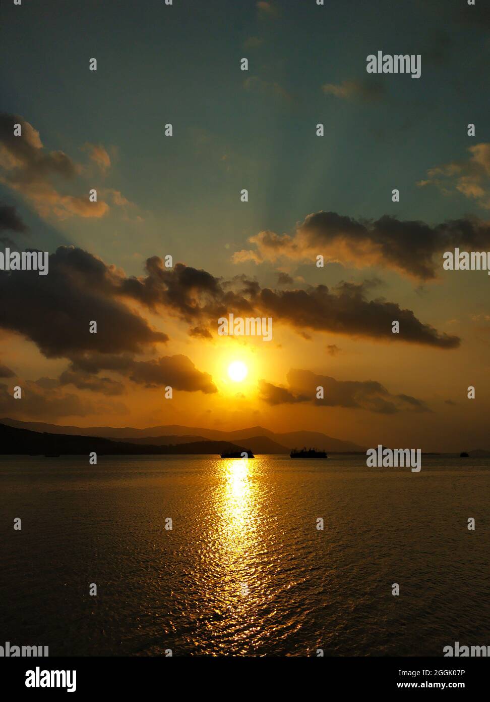 Fiery sunset with clouds by the ocean Stock Photo - Alamy