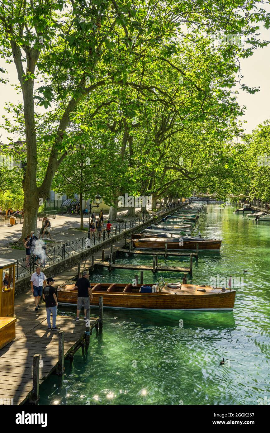 Tourist landing on the Canal du Vassè.These moorings are covered with century-old plane trees with a direct view of the Pont des Amours.Annecy, France Stock Photo