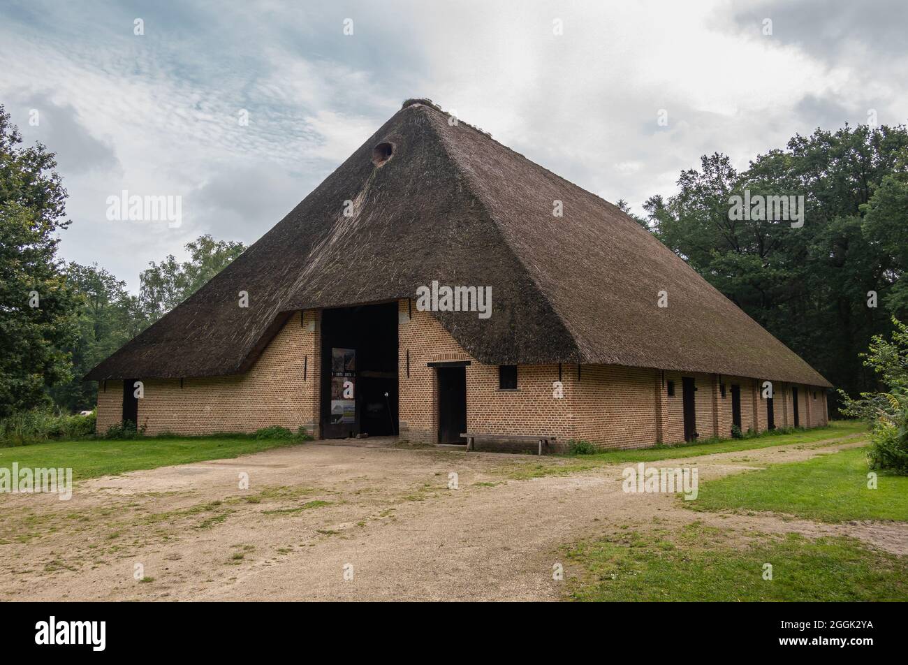 Genk, Belgium - August 11, 2021: Domein Bokrijk. Giant barn with beige  brick stone walls and giant dark gray straw roof under light blue  cloudscape. G Stock Photo - Alamy