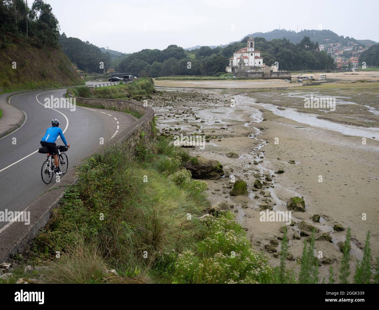 Road bike tour with luggage, bikepacking on a lonely coastal road in Asturias, northern Spain with a view of the Atlantic Stock Photo