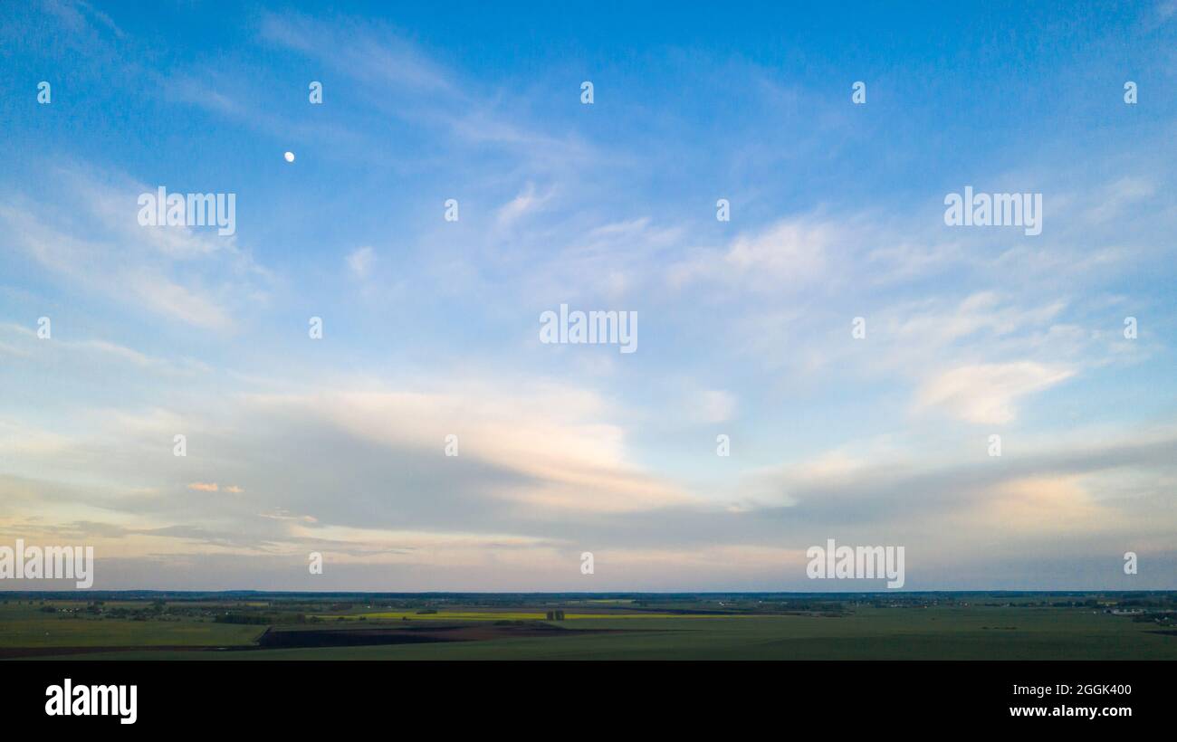 Green meadow under a blue sunset sky with clouds Stock Photo - Alamy
