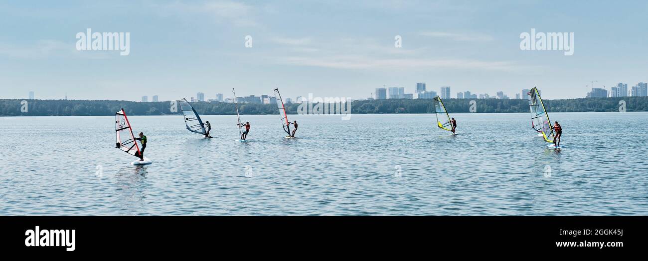 Windsurfing training. Several children floating on boards with sail on