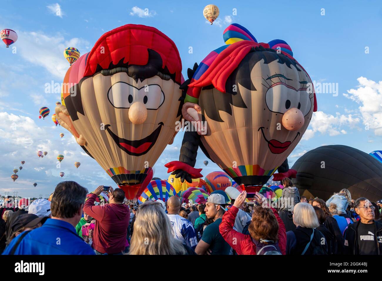 'Boy Balloon' (left) and 'Oons Wiefke' special shape hot air balloons and crowd, Albuquerque International Balloon Fiesta, Albuquerque, New Mexico USA Stock Photo
