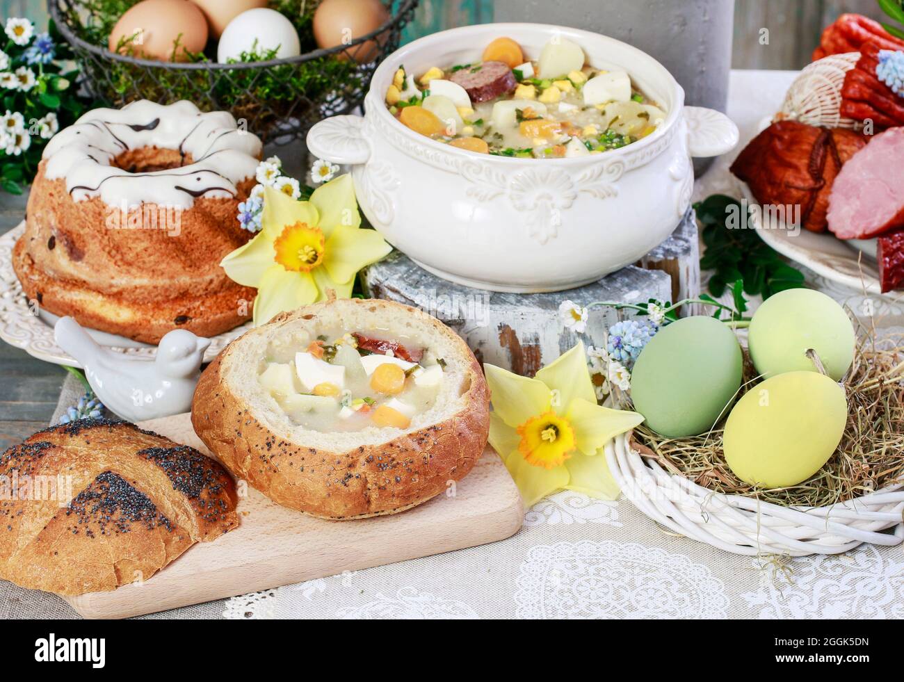 The sour rye soup, easter cakes and saussages on the table. Festive dish Stock Photo