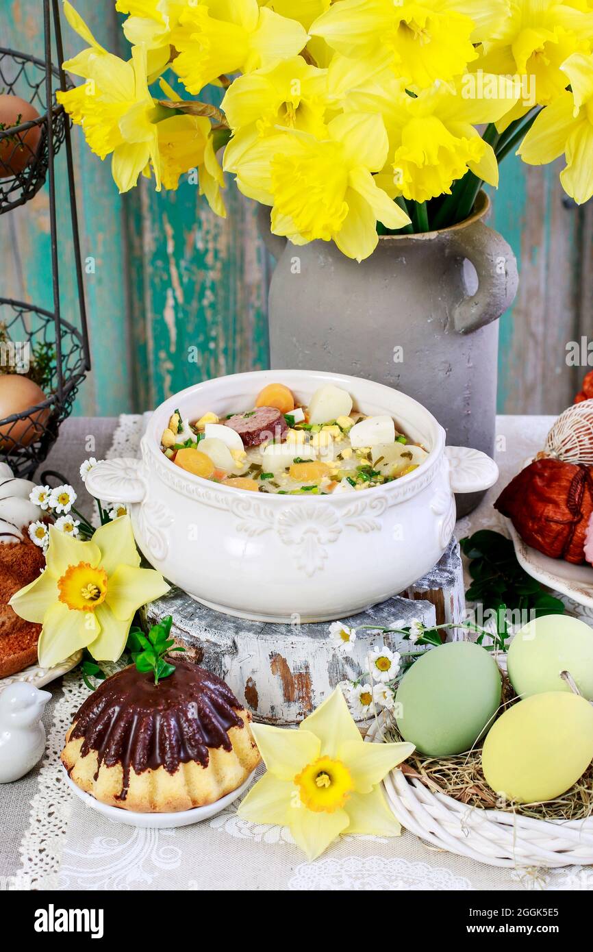 The sour rye soup, easter cakes and saussages on the table. Festive dish Stock Photo