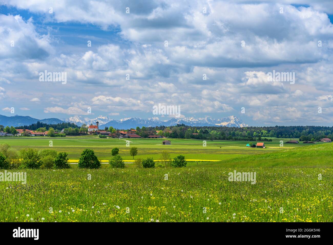 Germany, Bavaria, Upper Bavaria, Tölzer Land, Dietramszell, district Lochen, spring landscape and town view with St. Magdalena church against alpine chain Stock Photo