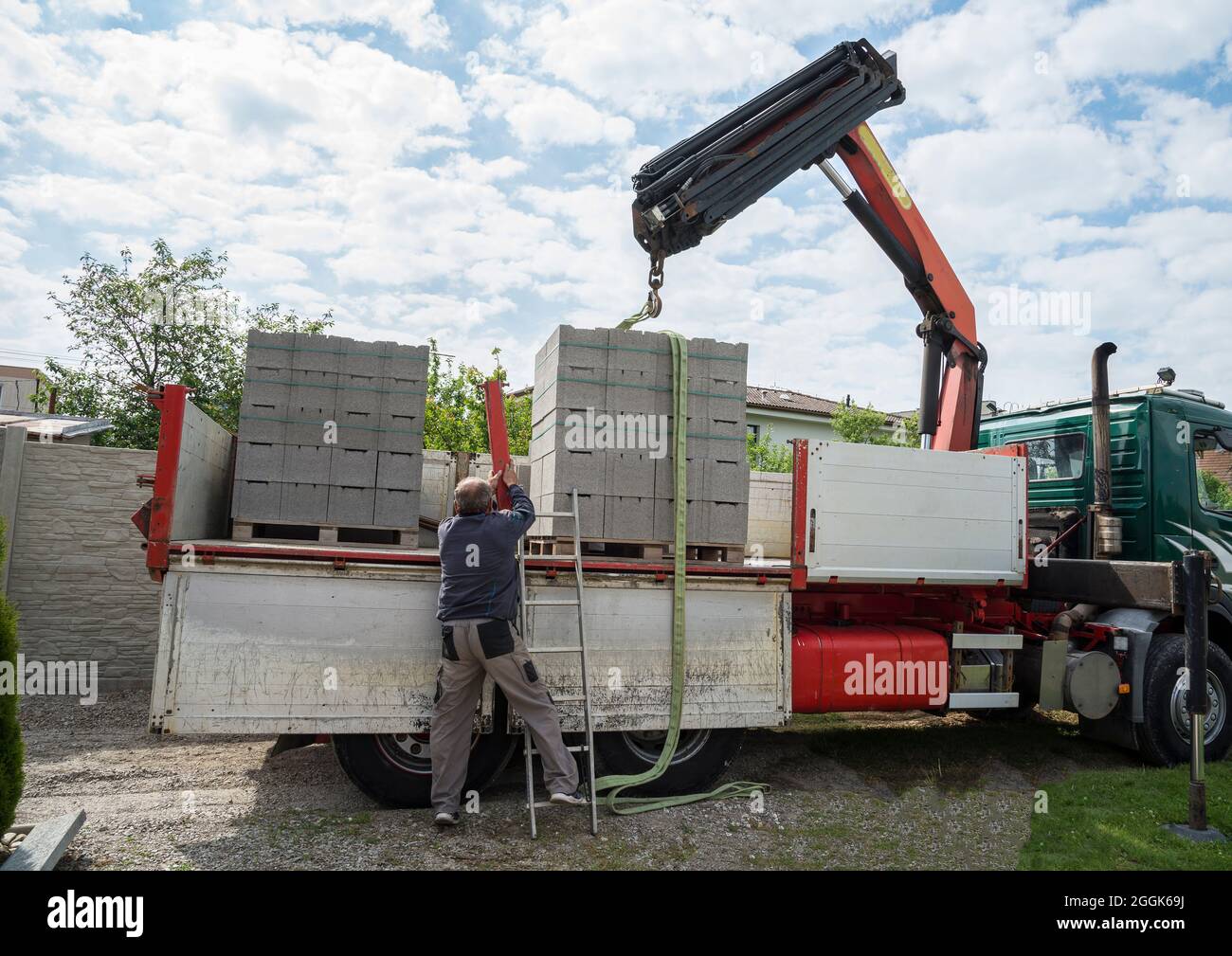 Hydraulic arm is unloading concrete block for a house Stock Photo Alamy