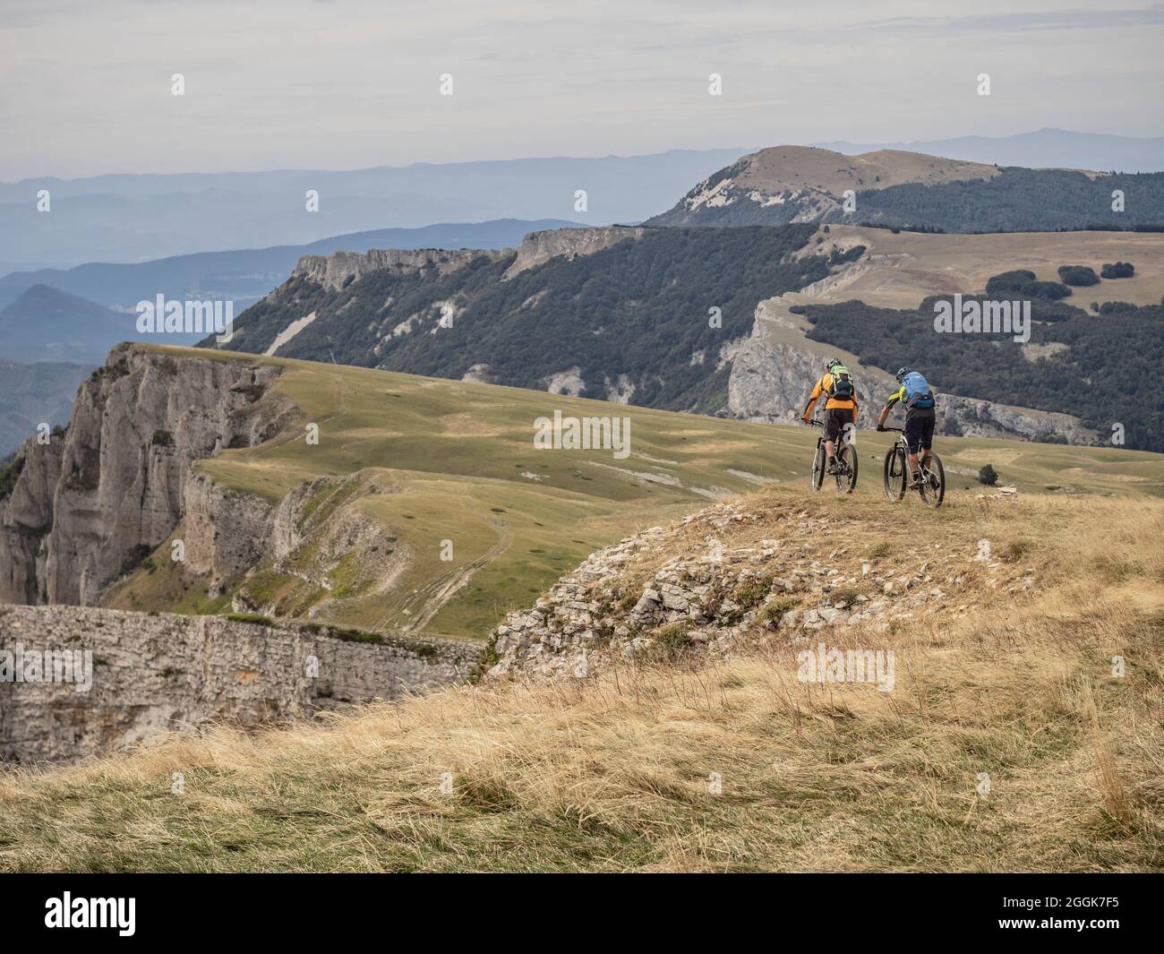 Mountain bikers on single trails on tour through the Hauts-Plateaux du Vercors nature reserve, Auvergne-Rhône-Alpes. At the edge between Pas des Ècondus and Pas de l'Èchelette near the Col du Rousset - view to the south. Stock Photo