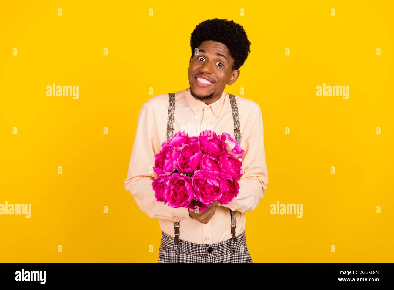 Photo portrait man in shirt giving flowers bunch on birthday party isolated vivid yellow color background Stock Photo