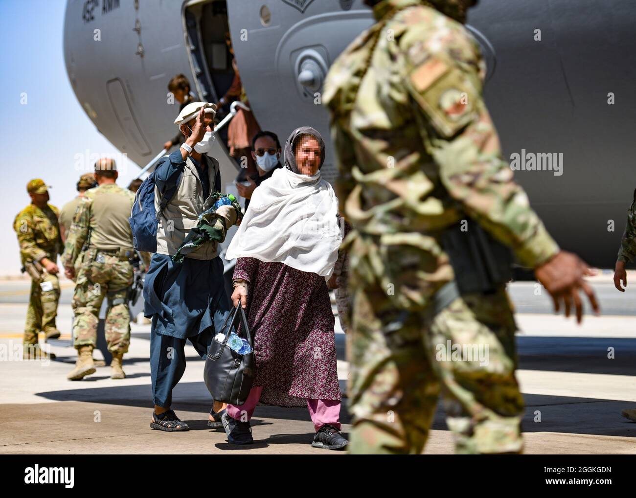Afghan evacuees leave a U.S. C-17 Globemaster after arriving to Ali Al Salem Air Base, Kuwait, August 26, 2021. The Department of Defense is committed to supporting the evacuation of American citizens, Special Immigrant Visa applicants and other at-risk individuals from Afghanistan. (U.S. Air Force photo by Staff Sgt. Ryan Brooks) Stock Photo