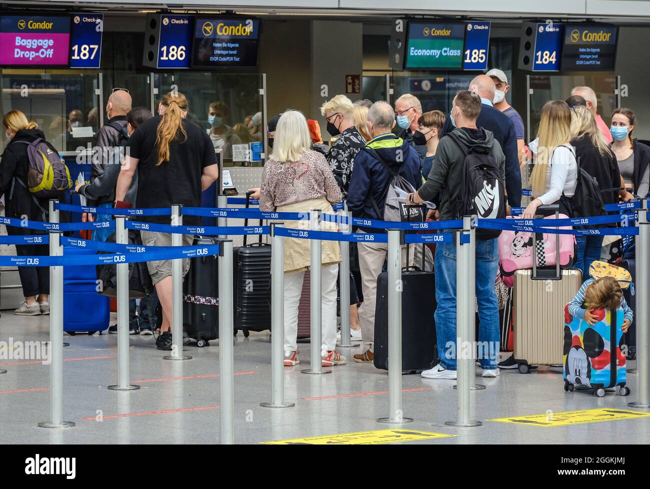 Duesseldorf, North Rhine-Westphalia, Germany - Duesseldorf Airport, holiday  start in NRW, vacationers stand in line with suitcases at the Condor  check-in counter in times of the corona pandemic on their way to