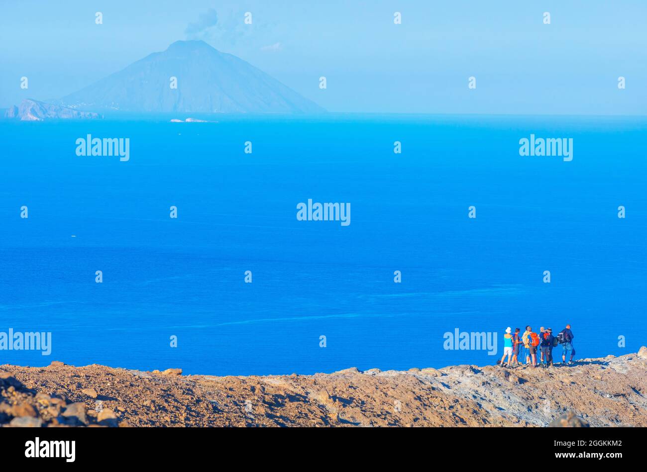 People enjoying views of Stromboli island from Gran Cratere rim, Vulcano Island, Aeolian Islands, Sicily, Italy Stock Photo