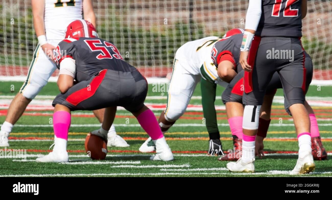 High school football quarterback is about to receive the ball from the