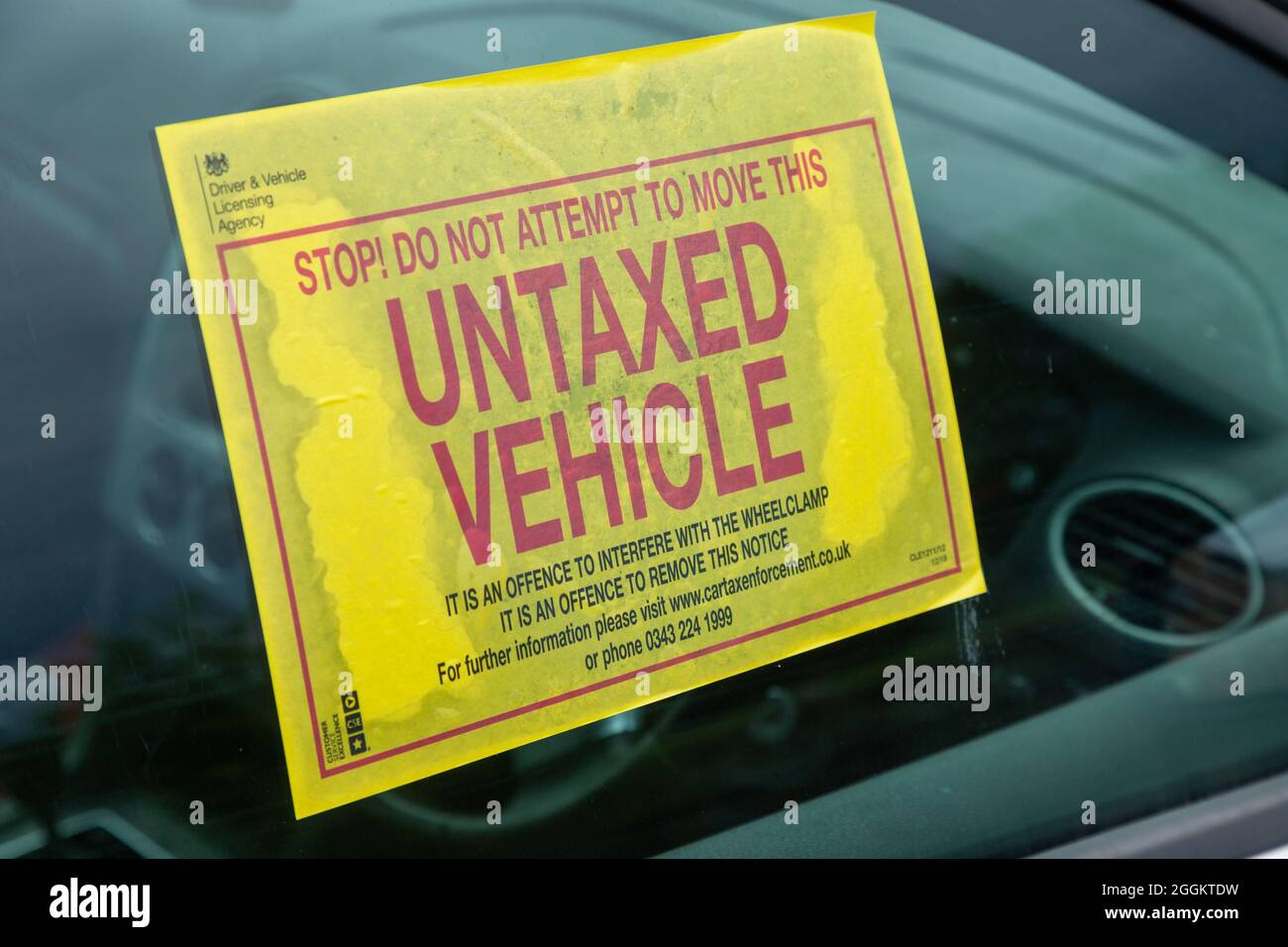 A waring sticker in a car window for being not road taxed Stock Photo