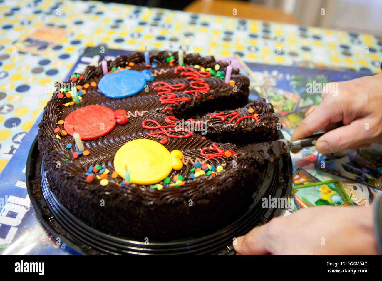 Man  cutting chocolate birthday cake, close up - USA Stock Photo