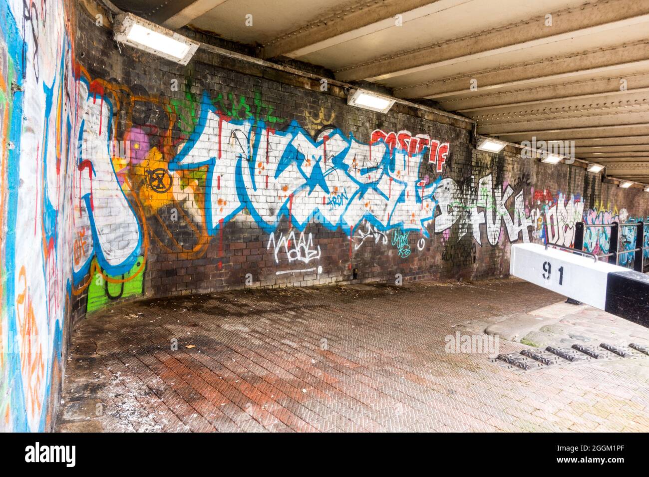 Manchester canal walkway walls filled with graffiti paints and the floor are filthy with anti-social behavior Stock Photo